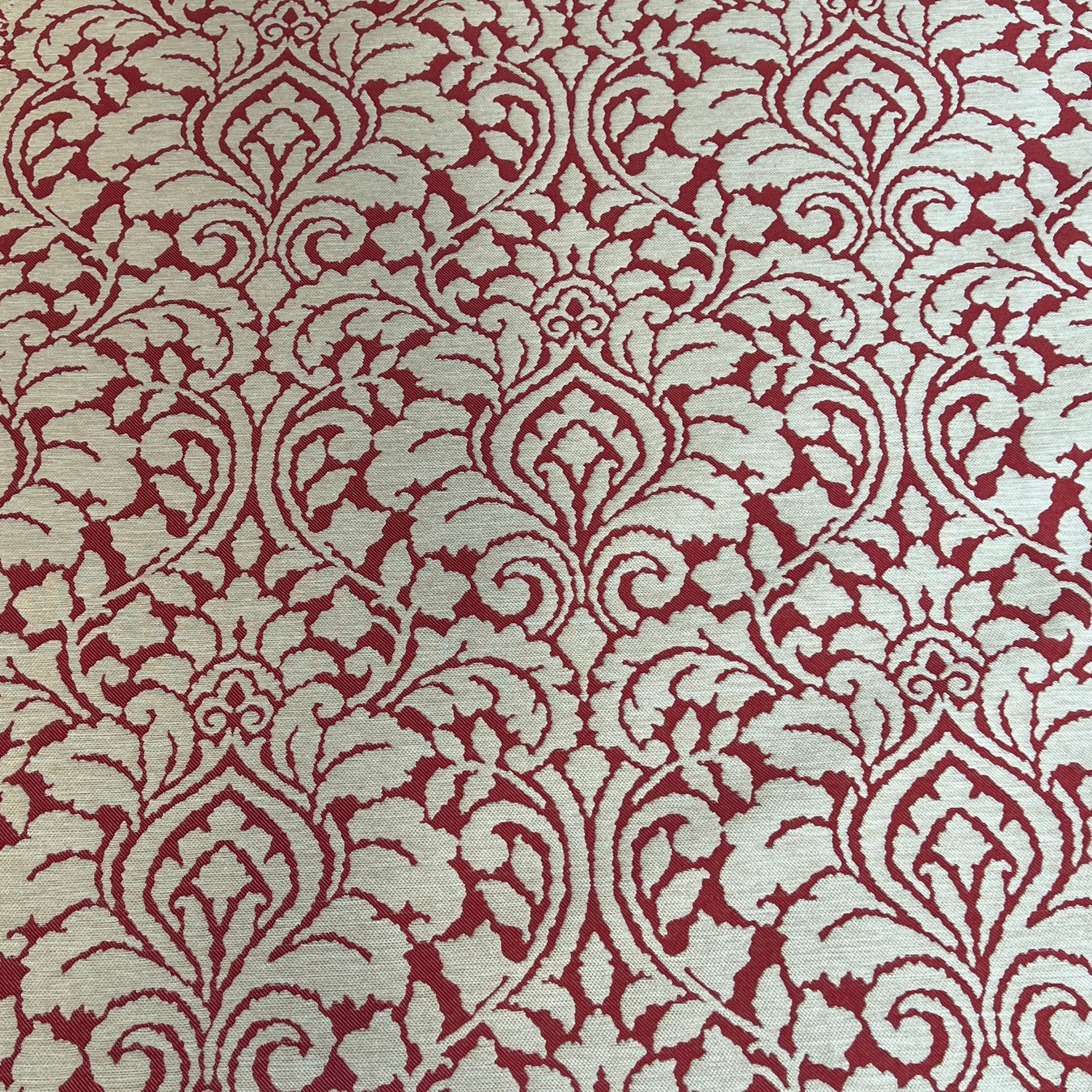 Red and beige damask patterned fabric shown in a close-up texture view.