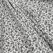 Soft woven cotton lawn with a small floral pattern (or ditsy design) in black line art