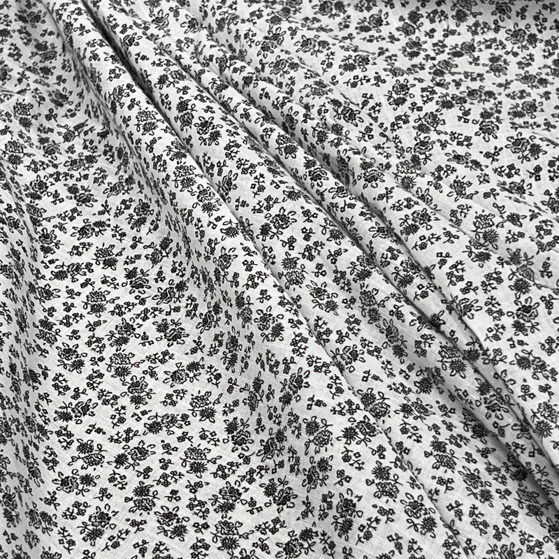 Soft woven cotton lawn with a small floral pattern (or ditsy design) in black line art