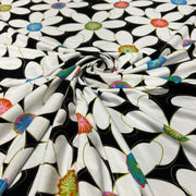 Cotton jersey knit fabric with large format floral print on black background. 