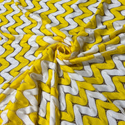 Yellow and white crochet fabric interlocking zigs and zags of white and yellow