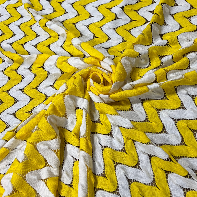 Yellow and white crochet fabric interlocking zigs and zags of white and yellow