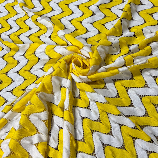 Yellow and white crochet fabric interlocking zigs and zags of white and yellow