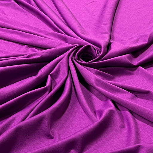 Soft and stretchy double knit ponte fabric with lycra draped in a swirl. Seen in a gorgeous magenta purple color
