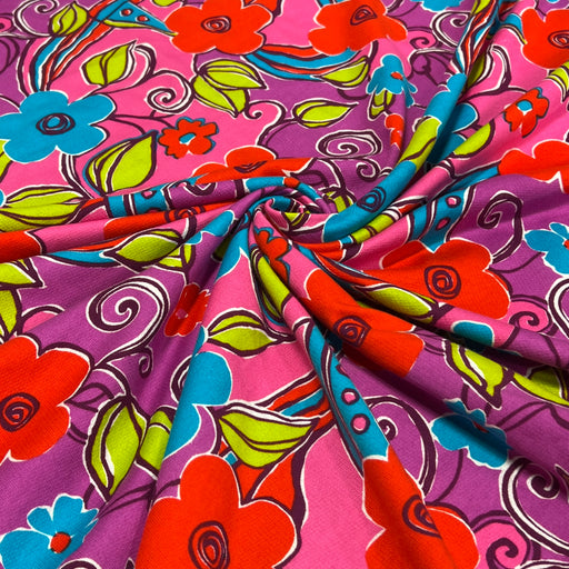 Lightweight cotton French terry fabric featuring bold and vibrant floral and swirl pattern in neon pink, purple and blue
