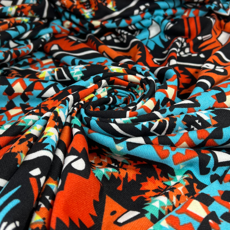 Colorful fabric with abstract pattern in orange, blue, black, and white.