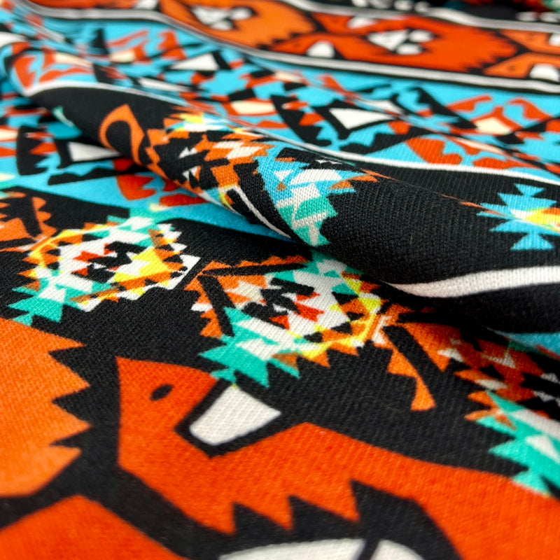 Close-up of fabric with a colorful pattern featuring animals and geometric shapes.