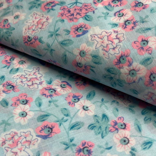 Floral fabric pattern with pink and purple flowers on a light blue background