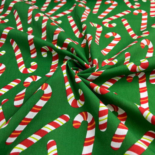 Fabric with candy cane pattern on a green background