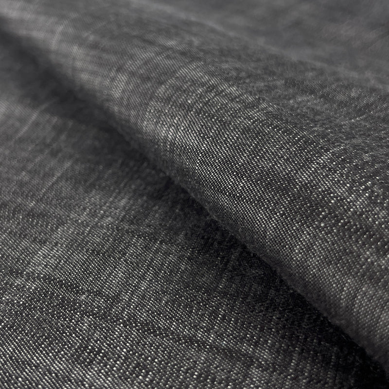 Close-up of dark charcoal grey 100% tencel denim with subtle sheen and a fine twill weave
