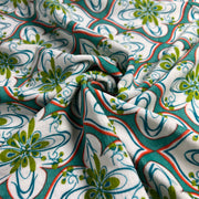 Close-up of patterned fabric with green, blue, and red design on white background