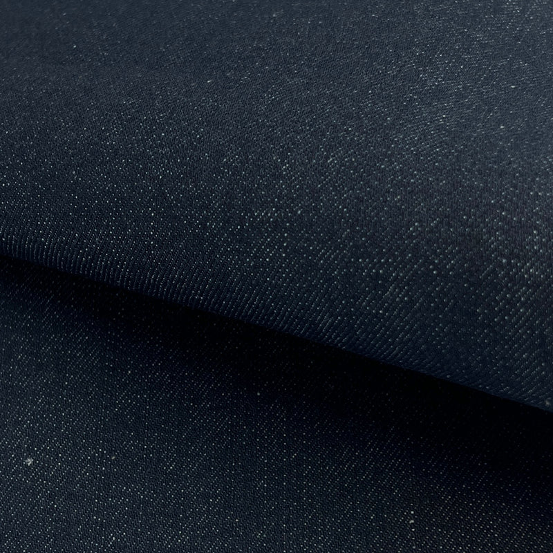 Close-up of dark blue denim fabric with a subtle texture.