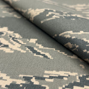 Digital camouflage fabric with a pixelated pattern on gray background