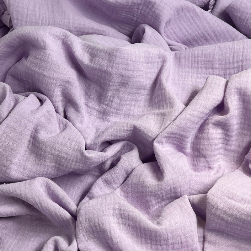Close-up of soft, light purple bubble gauze fabric with a textured surface weave.
