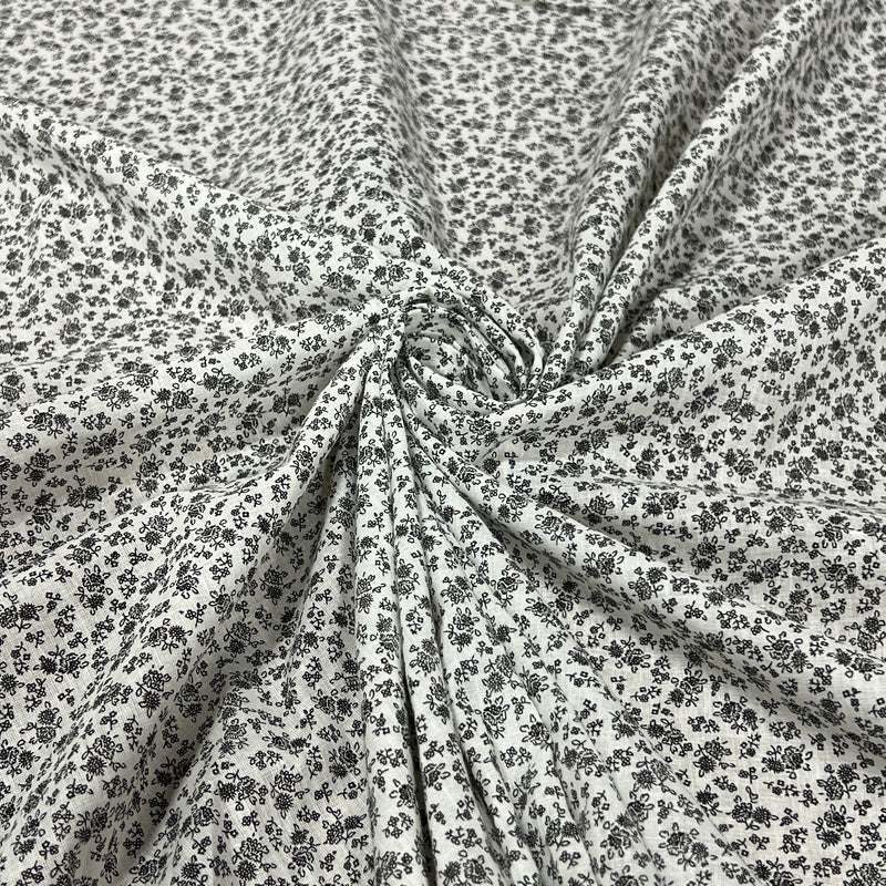 Soft cotton lawn featuring a small floral (or ditsy) print in fine black detail
