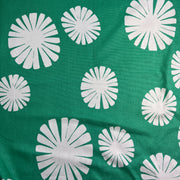 White floral patterns on a green fabric background