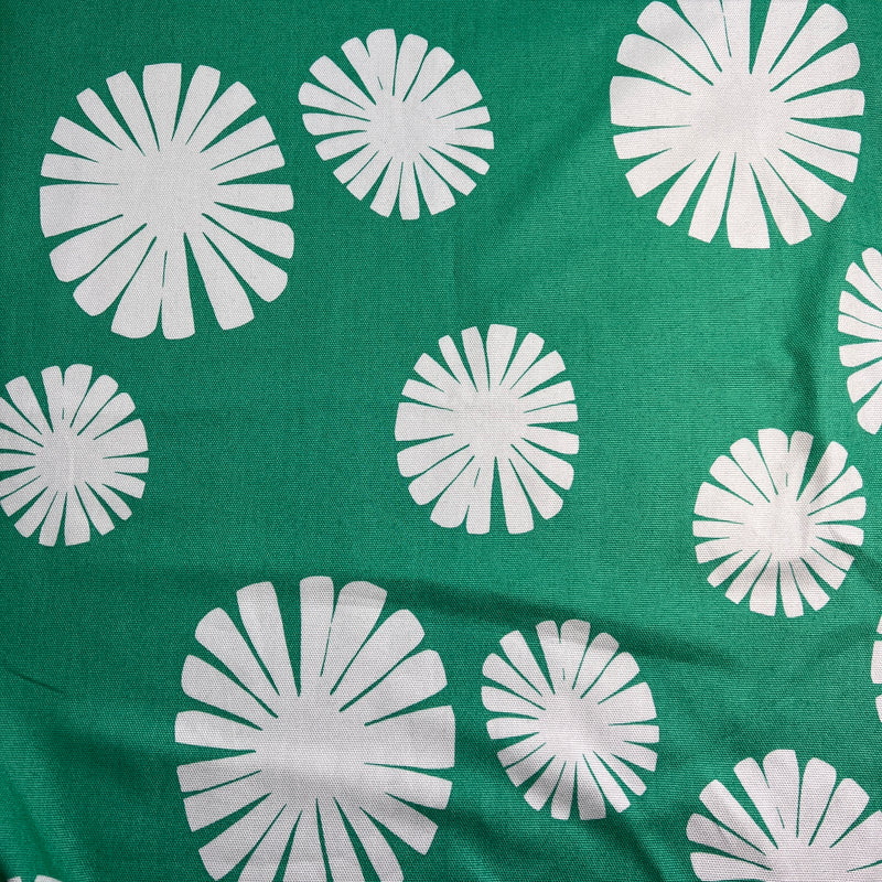 White floral patterns on a green fabric background
