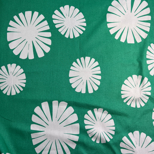 White floral patterns on a green fabric background