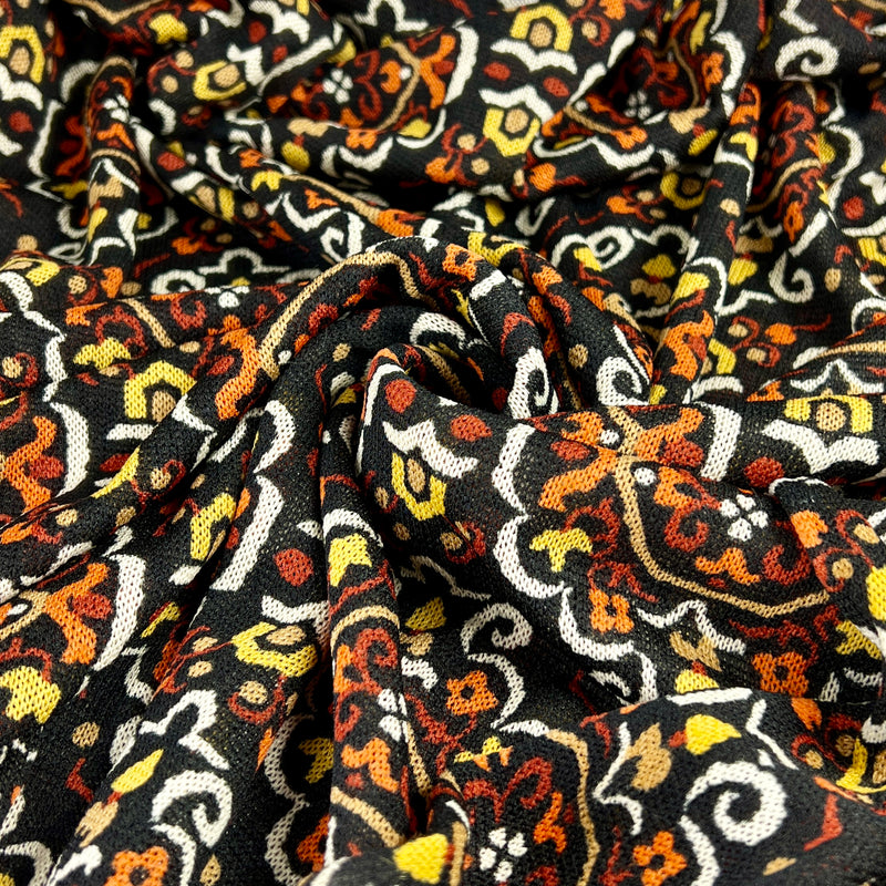 Close-up of patterned fabric with intricate design on a black background
