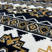 Close-up of a patterned fabric with black, gold, and white colors.