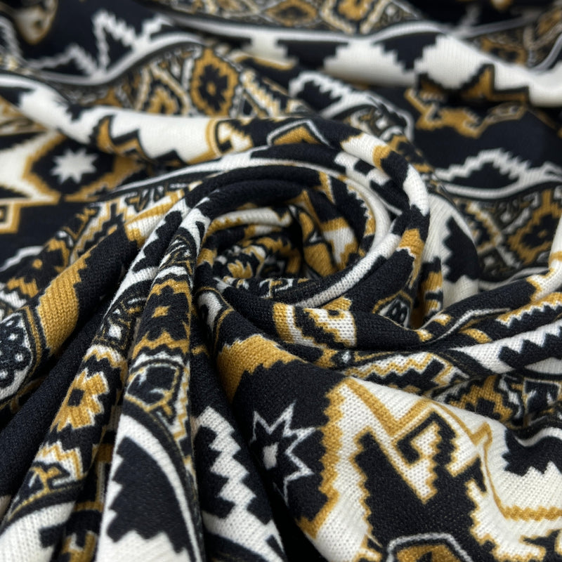 Close-up of patterned fabric with black, gold, and white colors.