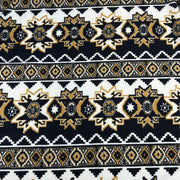 Patterned fabric with black, gold, and white design on a black background