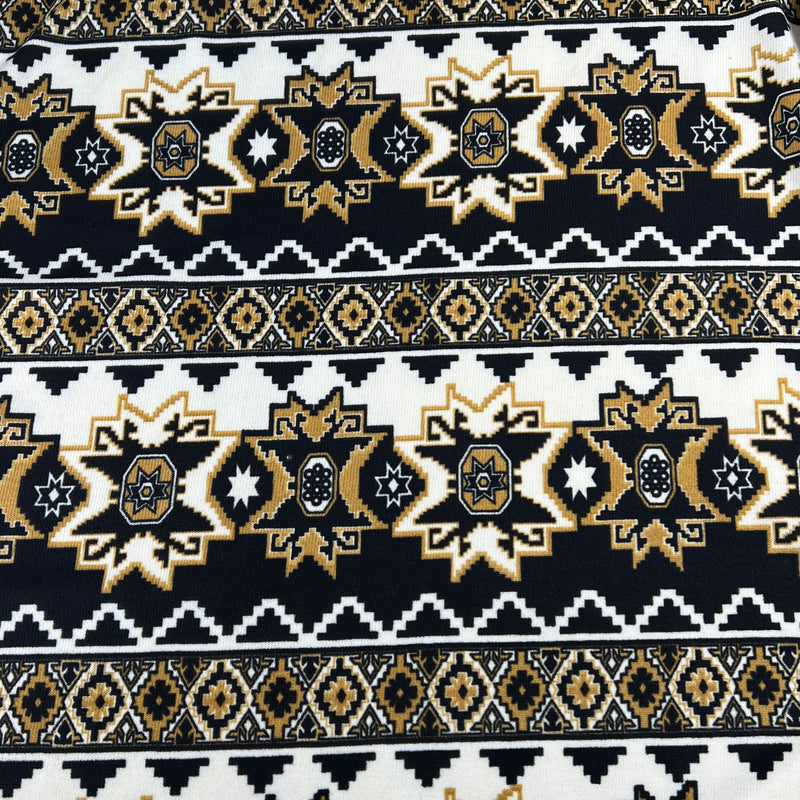 Patterned fabric with black, gold, and white design on a black background