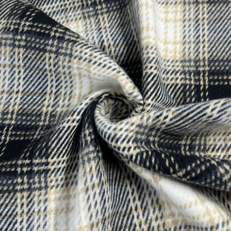 Close-up of plaid heavyweight flannel fabric with black, white, and beige colors.