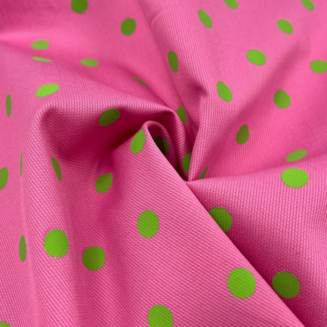Pink fabric with green polka dots