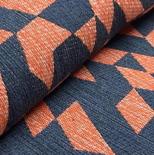 Close-up of a textured fabric with a geometric pattern in navy and orange.