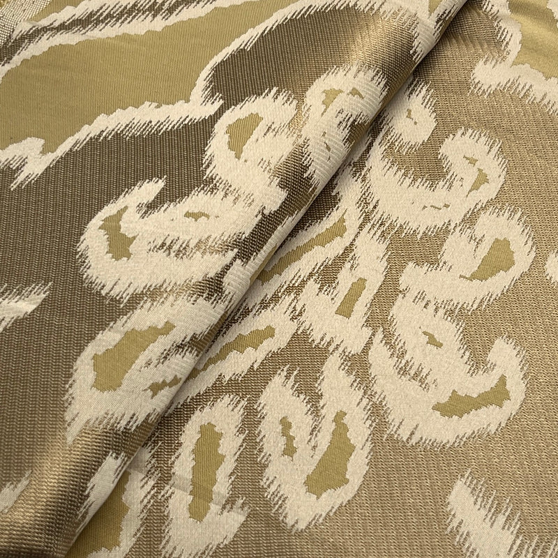 Textile with a pattern of abstract shapes in beige and brown on a beige background