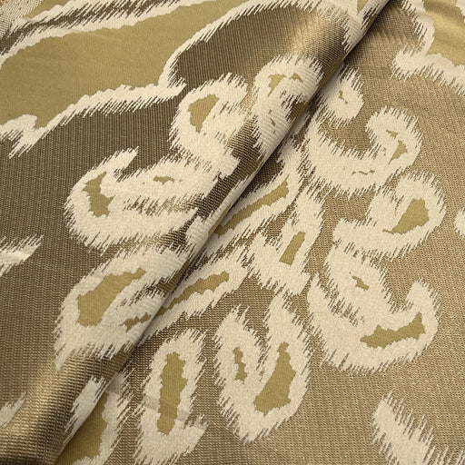 Textile with a pattern of abstract shapes in beige and brown on a beige background