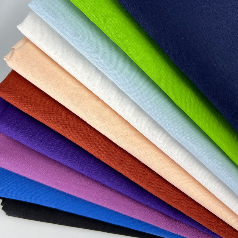Stack of colorful fabric swatches in various colors.