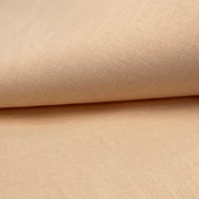 Closeup of a cotton/polyester broadcloth fabric in a peachy pink color