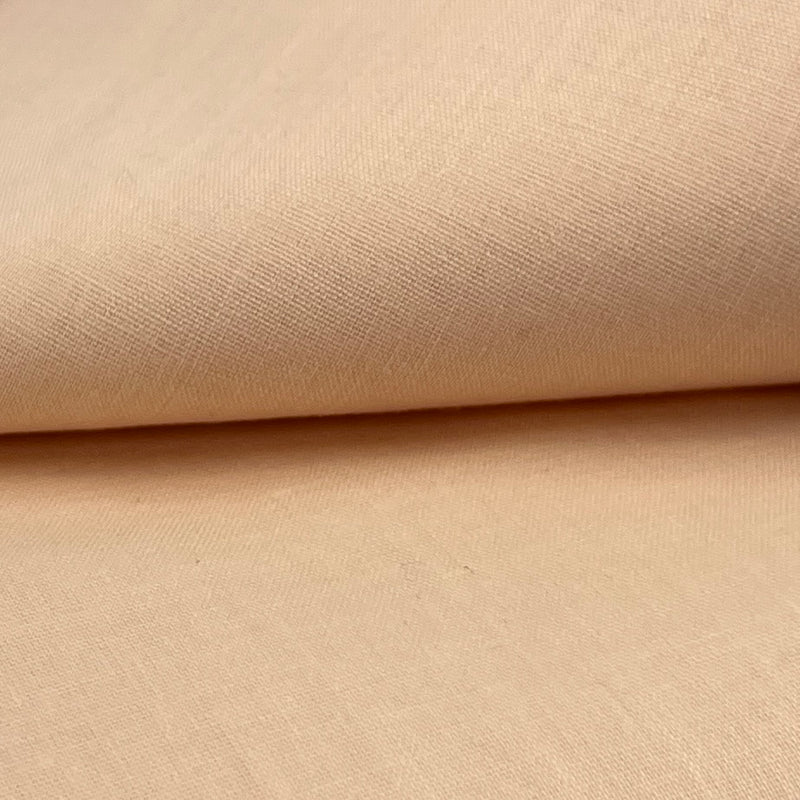 Closeup of a cotton/polyester broadcloth fabric in a peachy pink color