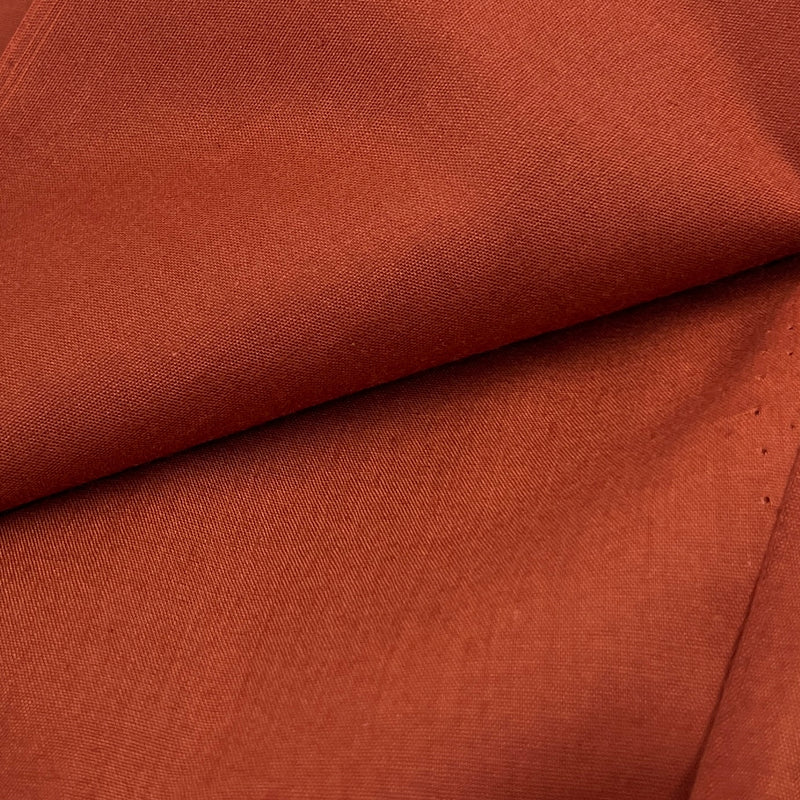 Close-up of rust colored, orange brown fabric with a subtle texture
