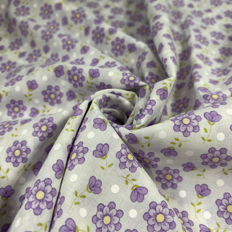 Floral fabric with purple flowers and white polka dots on a light background
