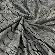 Grey fabric with slate like pattern, textured with flocked zebra stripes which are outlined in glitter