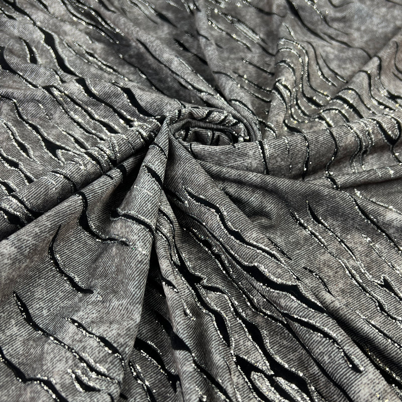Grey fabric with slate like pattern, textured with flocked zebra stripes which are outlined in glitter