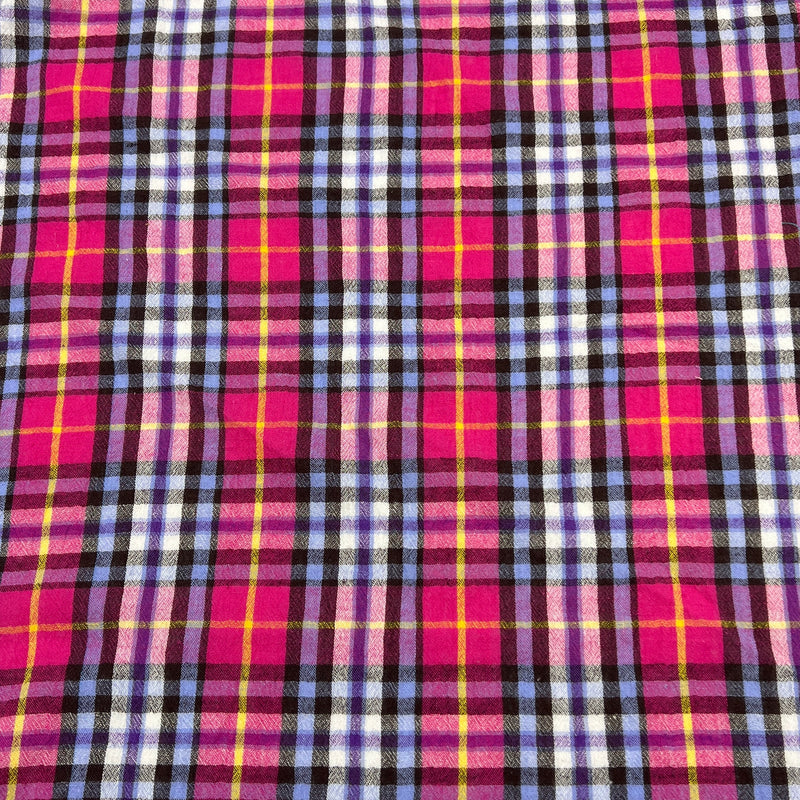 Plaid fabric with pink, purple, and yellow pattern laid flat to show pattern