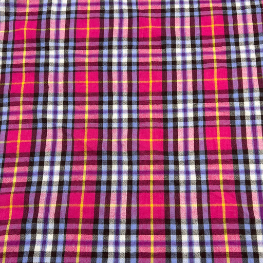 Plaid fabric with pink, purple, and yellow pattern laid flat to show pattern
