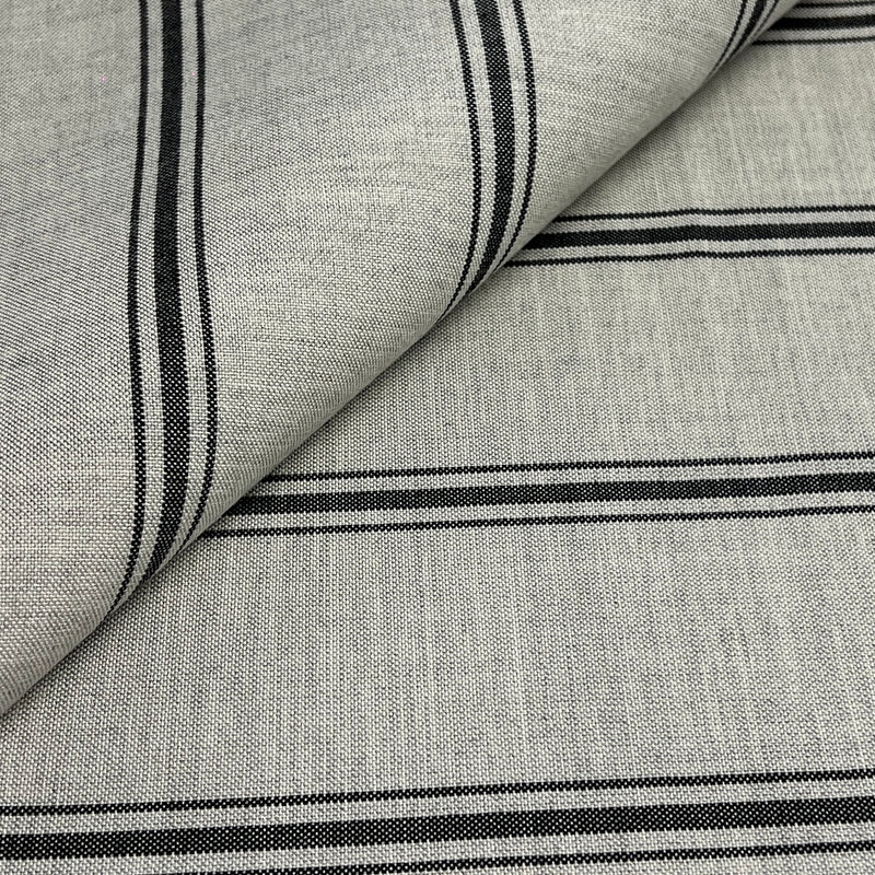 A close-up of woven fabric with a light gray base and black horizontal stripes, shown with one corner folded over to reveal the texture.