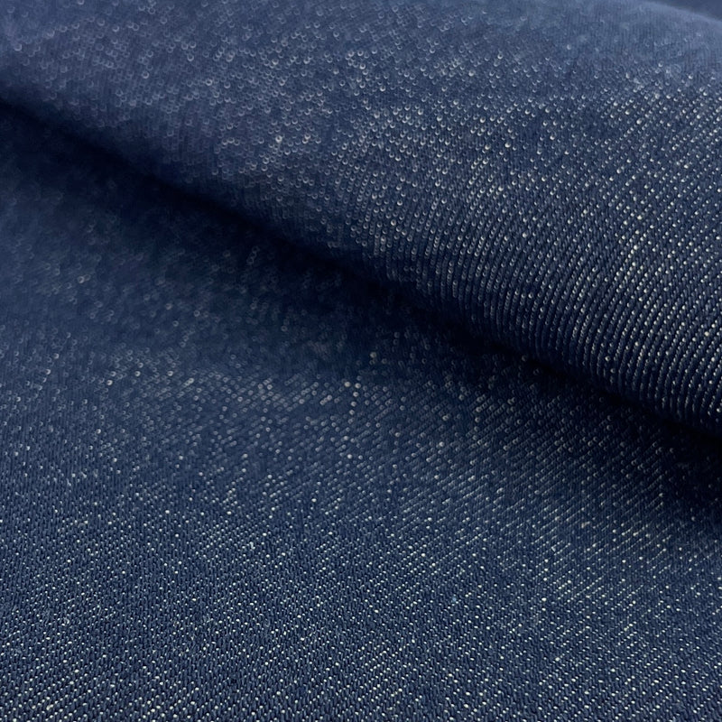 Close-up of dark blue denim fabric with a subtle texture.