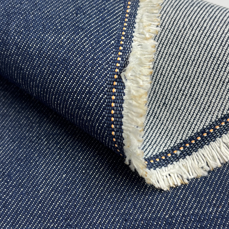 Close-up of blue denim fabric with frayed edge