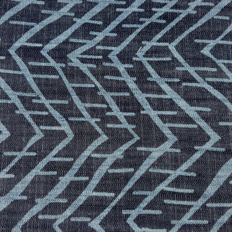 Close-up of a lightweight tencel denim with a geometric pattern on a dark indigo background
