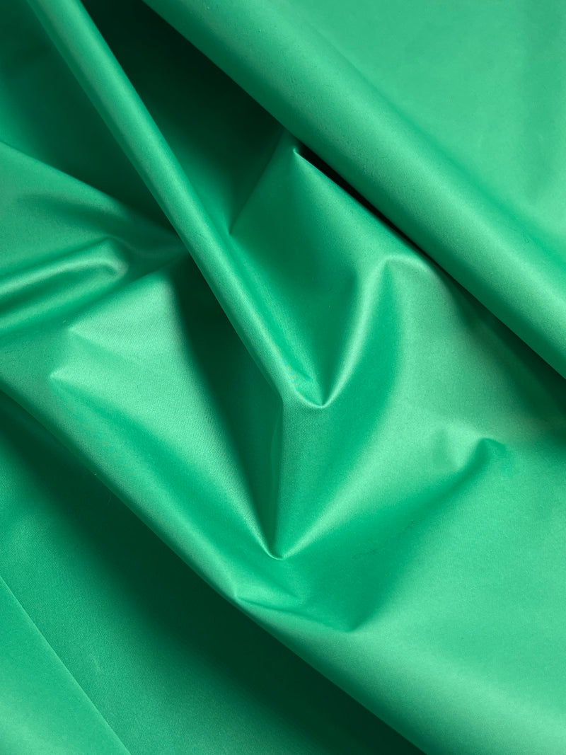 Close-up of green water repellent polyester woven fabric with folds