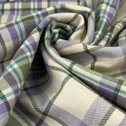 Close-up of plaid fabric with purple, green, and white colors.