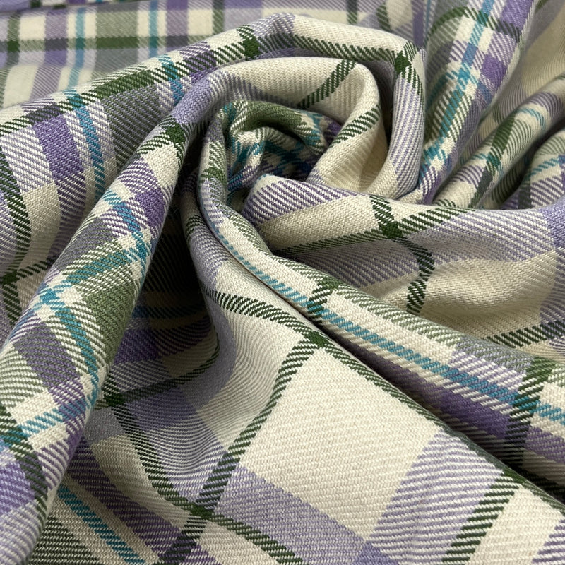 Close-up of plaid fabric with purple, green, and white colors.