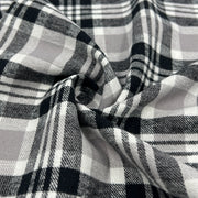 Lightweight cotton flannel shirting fabric featuring a tartan plaid design of black, white & taupe.