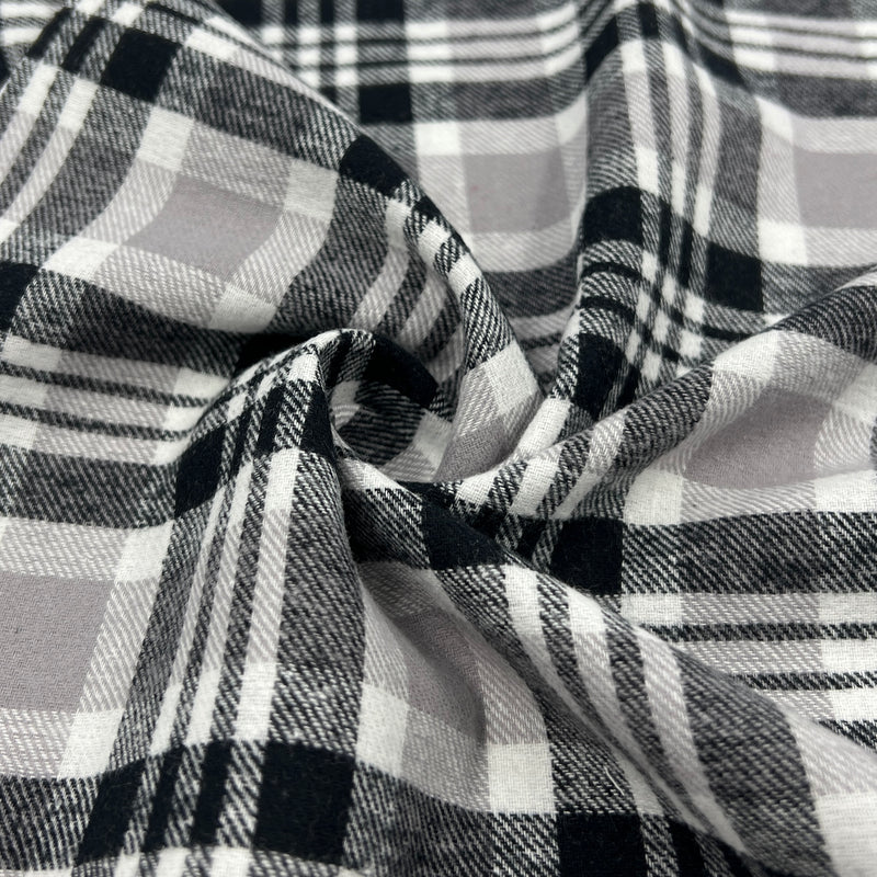 Lightweight cotton flannel shirting fabric featuring a tartan plaid design of black, white & taupe.